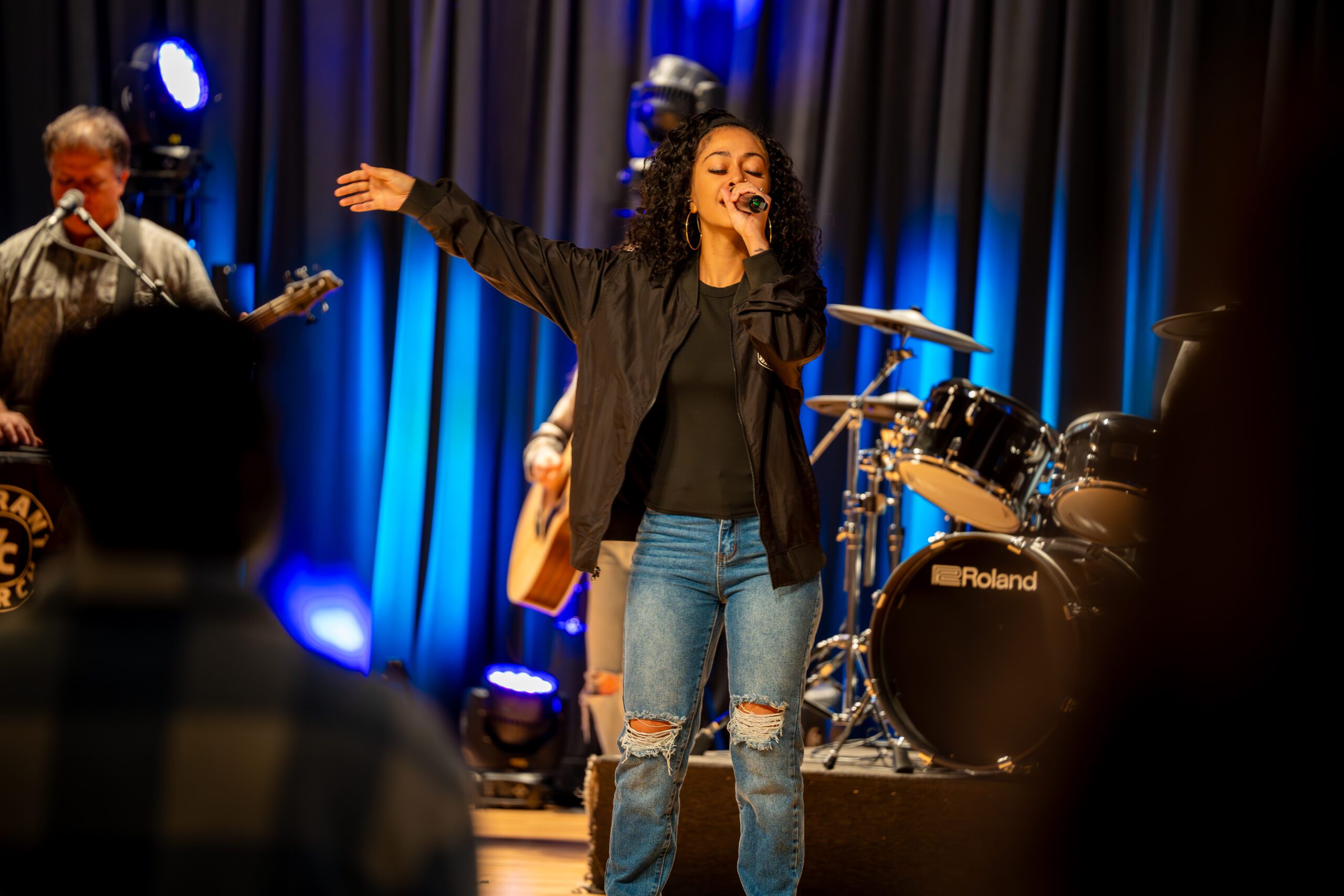 Worship leader singing with the band during a Sunday service at Vibrant Church in Davie, FL